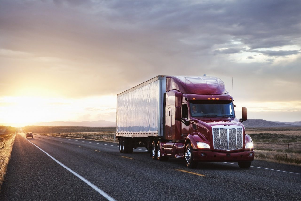 3/4 front view of a commercial truck on the road at sunset in eastern Washington, USA