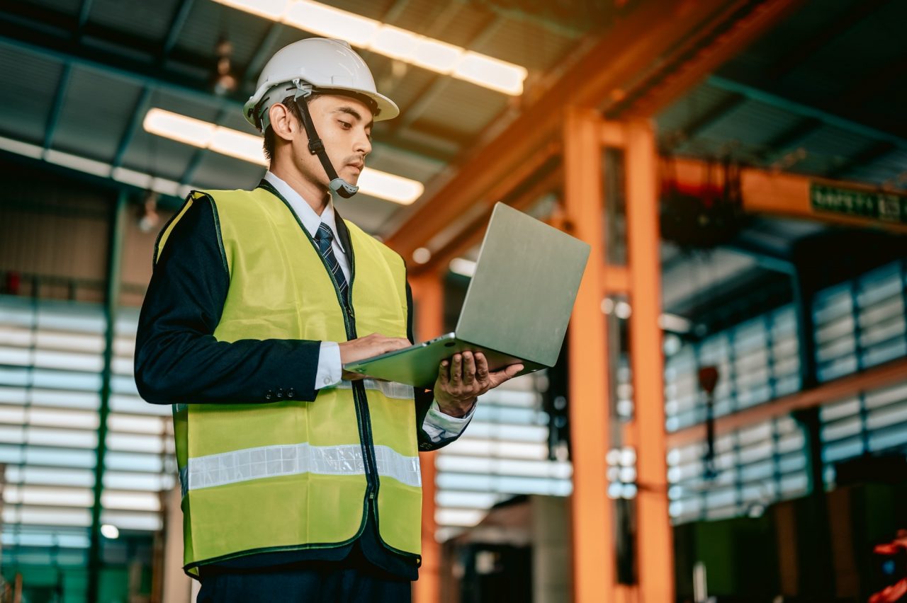 Businessman engineer using software virtual reality in laptop to monitoring machine in real time.