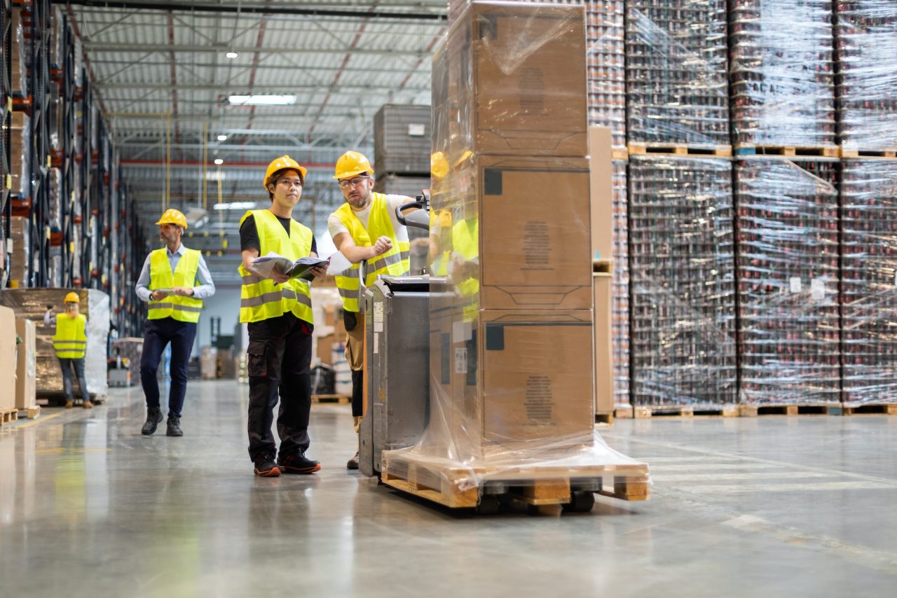 Employees consult while working in the warehouse